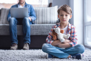 Kind und Vater sitzen im Wohnzimmer